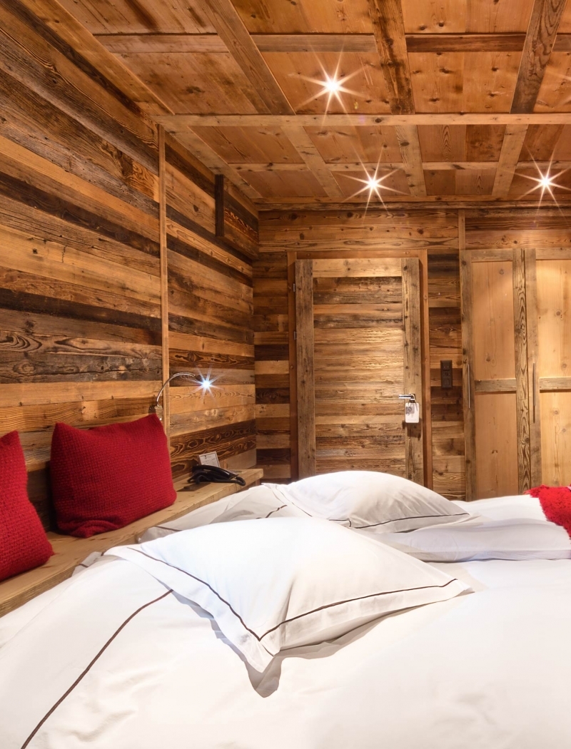 Une chambre chaleureuse où le charme alpin rencontre le confort d'un hôtel 5 étoiles à Crans-Montana.